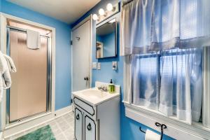 a bathroom with blue walls and a sink and a window at Cottage on the Cove in Wells +42 photos