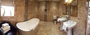 a bathroom with a tub and two sinks and a bath tub at The White Hart in Great Yeldham