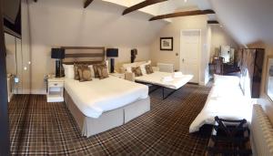 a large bedroom with two beds and a couch at The White Hart in Great Yeldham