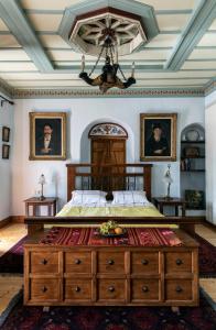 a bedroom with a large bed with a wooden dresser at Kanto's Guesthouse in Stemnitsa