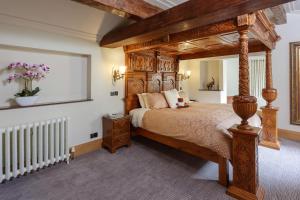 een slaapkamer met een groot houten hemelbed in een kamer bij The Saddleworth Hotel in Diggle