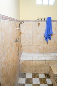 a bathroom with a shower with a blue towel at BALI BAMBOO JUNGLE HUTS AND HOSTEL in Tampaksiring