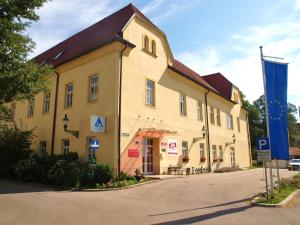 un grand bâtiment jaune avec un panneau devant lui dans l'établissement Junges Hotel Tulln, à Tulln