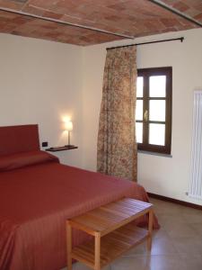1 dormitorio con cama roja y ventana en B&B Cascina Gaione Via Gallina,18b 12052 Neive cn en Neive
