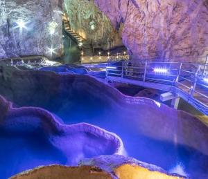 una grande piscina di acqua blu in una grotta di Zlatiborska vila 2 a Zlatibor