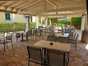 a group of tables and chairs under a pavilion at Oula Maisonettes Suites in Kavos