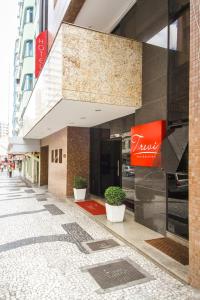 um edifício com uma placa no lado de uma rua em Trevi Hotel e Business em Curitiba