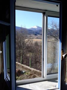 a window with a view of a mountain view at Vue sur L'Ourtizet in Rodome