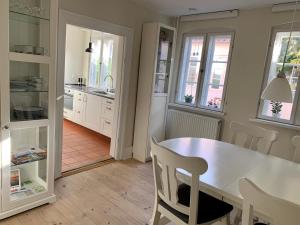 uma cozinha com mesa, cadeiras e janelas em Ribe Sønderport Bed & Kitchen em Ribe