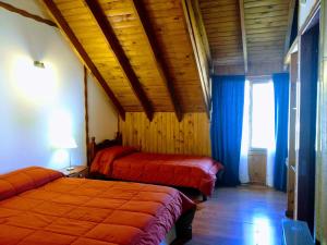 a bed room with two beds and a window at Lo de Guille in El Chalten