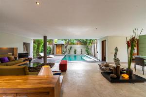 a living room with a swimming pool in a house at Villa Athena in Seminyak