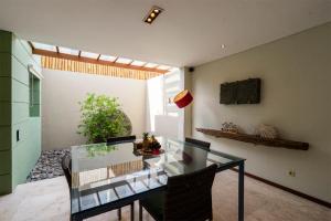 a dining room with a glass table and chairs at Villa Athena in Seminyak