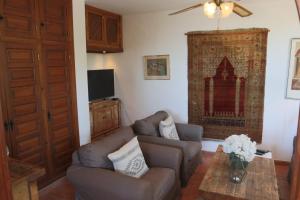 salon z kanapą i stołem w obiekcie Cortijo La Palmera, Frigiliana w mieście Frigiliana