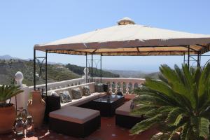 - une terrasse avec un grand parasol au-dessus d'une maison dans l'établissement Cortijo La Palmera, Frigiliana, à Frigiliana