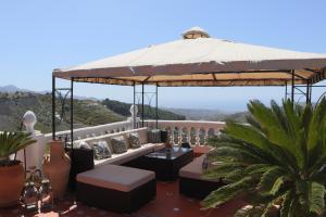 patio z dużym parasolem na dachu domu w obiekcie Cortijo La Palmera, Frigiliana w mieście Frigiliana