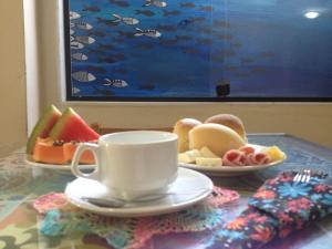 einen Tisch mit einer Tasse Kaffee und Obstteller in der Unterkunft Pousada dos Sonhos in Angra dos Reis