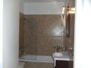 a bathroom with a sink and a tub and a toilet at Dandy Suites in Mar de las Pampas +49 photos