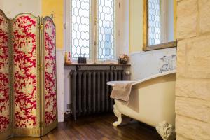 La salle de bains est pourvue d'une baignoire et d'un radiateur. dans l'établissement Chambre d'hôtes Le Petit Tertre, à Dijon