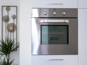 a stainless steel oven in a kitchen with a plant at La Casa Verde - Apartment in Lasino