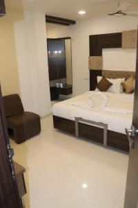 een slaapkamer met een groot bed en een stoel bij Hotel Park Residency in Vijayawāda