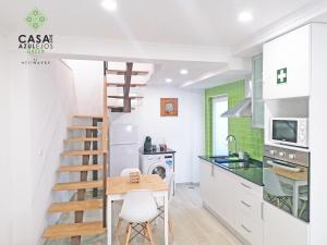 a kitchen with a staircase and a table and chairs at Casa do AZULejo - Green in Peniche