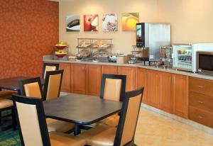 comedor con mesa y sillas y cocina en Country Inn & Suites by Radisson, Fayetteville I-95, NC, en Fayetteville