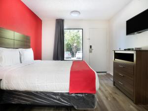 a hotel room with a bed with a red wall at OYO Hotel Decatur I-285 The Perimeter in Decatur
