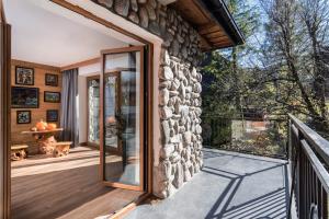 uma casa de pedra com uma porta de vidro num deque em Villa 9A em Zakopane