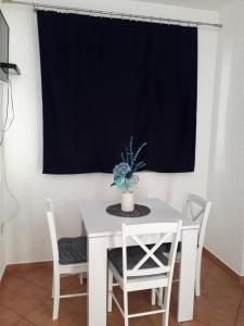 a white table and chairs in a room with a window at Delfin Apartments in Sveti Juraj