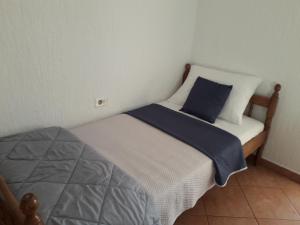 a small bedroom with a bed with a blue pillow at Delfin Apartments in Sveti Juraj
