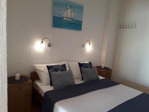 a bedroom with a bed with pillows and a boat on the wall at Delfin Apartments in Sveti Juraj