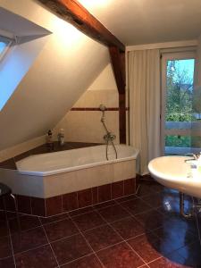 a attic bathroom with a tub and a sink at Drum &Dran in Kühlungsborn