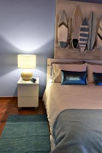 a bedroom with two beds and a lamp and a rug at Salty Stories in Ponta Delgada