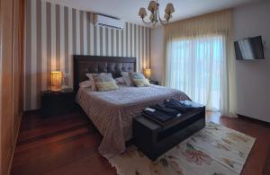 a bedroom with a bed and two lamps and a television at VILLA NELLY in Costa de Antigua