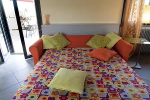 a couch with pillows on top of a colorful table at Caise in Castelnuovo Magra