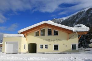 a building with snow on the roof at Apart La Vita in Sankt Anton am Arlberg