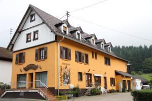 ein gelbes und weißes Gebäude mit schwarzem Dach in der Unterkunft Gästehaus Alexanna in Baden-Baden