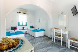 una camera con due letti e un tavolo con un cesto di frutta di Ragousis Apartments a Paroikia