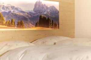 セルヴァ・ディ・ヴァル・ガルデーナにあるChalet Dumbria Dolomitesの壁に絵が描かれたベッドルームに白いベッド2台が備わります。