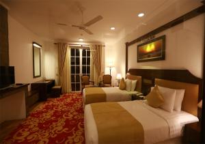 ヌワラエリヤにあるThe Blackpool Resort & Spaのベッド2台とテレビがあるホテルの部屋