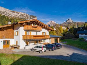 a house with two cars parked in a parking lot at Chalet Dumbria Dolomites in Selva di Val Gardena