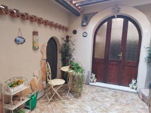 une terrasse avec une porte en bois, une table et des chaises dans l'établissement Casa dell'Artista singola indipendente, à Cagliari