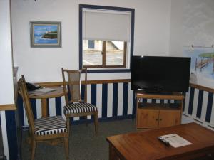 a living room with a television and a table and chairs at Boyne City Motel in Boyne City