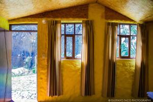 a room with three windows with a view of a mountain at Paraiso Las Palmeras Lodge in Cabanaconde