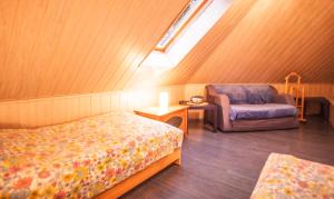 a bedroom with a bed and a chair and a window at Domek Epona in Szklarska Poręba