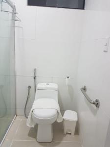 bagno bianco con servizi igienici e doccia di Residencial e Pousada Sea La Vie a Maragogi