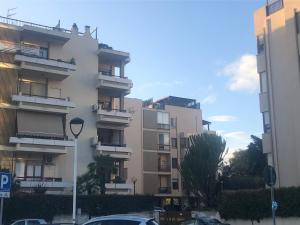 un edificio alto con macchine parcheggiate di fronte di Elena’s home a Cagliari