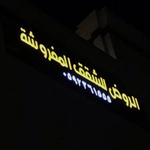 a neon sign on the side of a building at الروض للشقق المفروشه خاصة in Al Madinah