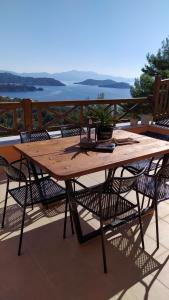 une table en bois avec des chaises assises sur une terrasse dans l'établissement Skiathos Gea Villas, à Achladies