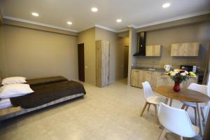 sypialnia z łóżkiem i stołem oraz kuchnia w obiekcie Brick House II w mieście Tbilisi City